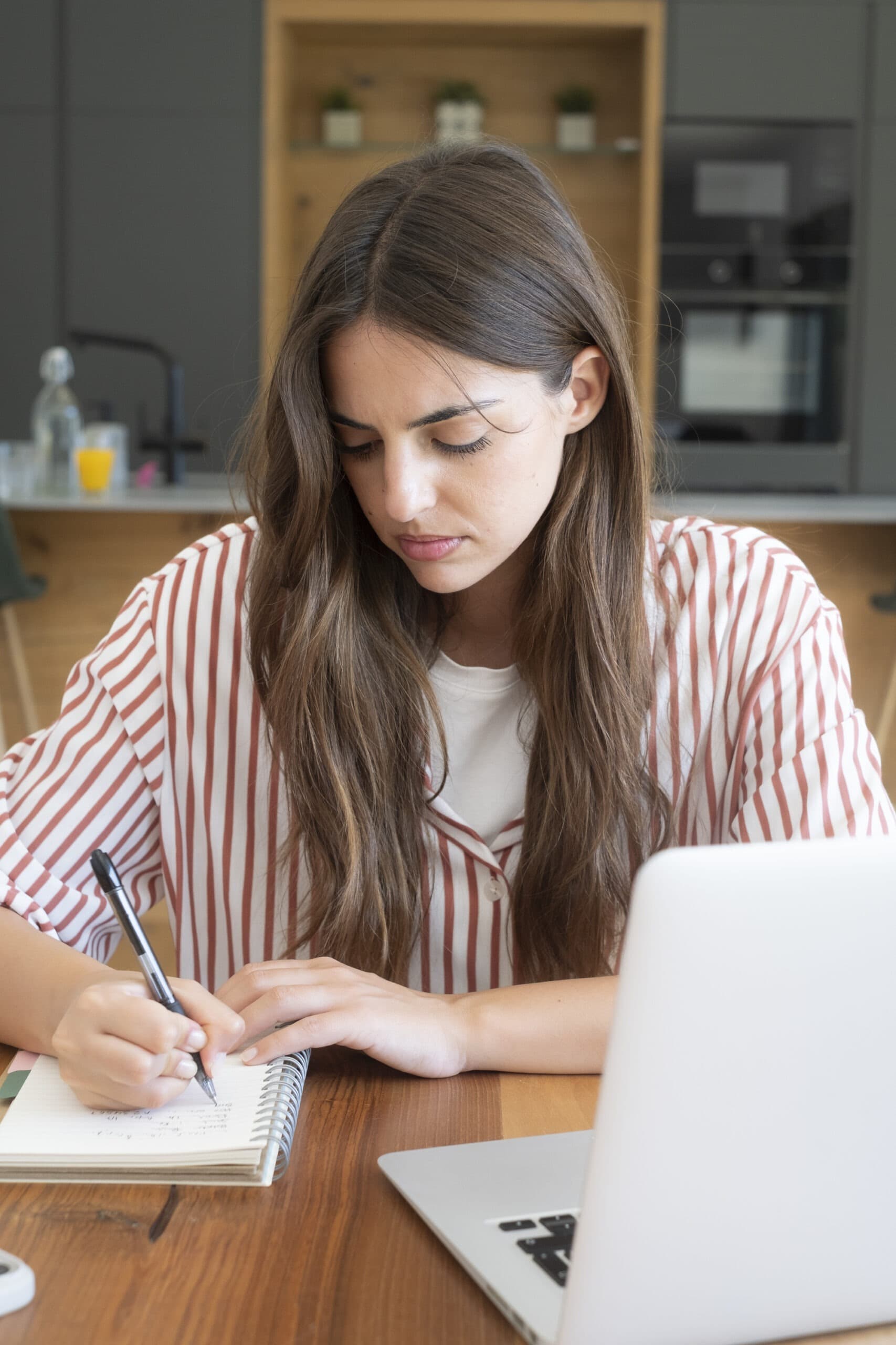 Student writing notes at a desk